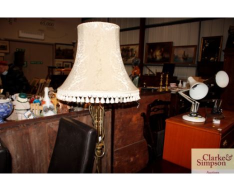An ornate brass standard lamp and shade 