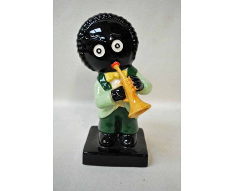 A large Carlton ware figure of a musician modelled as a Golliwog playing a trumpet, light and dark green colourway, stamped a