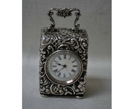 A Victorian silver cased miniature Carriage Clock, white circular enamel dial with Roman numerals, in a heavily foliate embos
