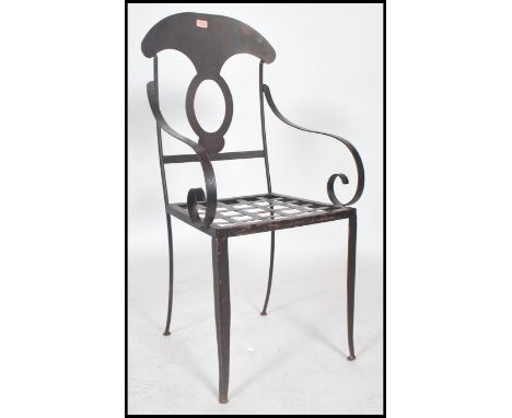 A vintage 20th century painted metal chair having scrolled arm rests with pierced back and seat having an ebonised finish.