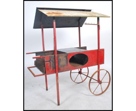 An unusual mid century Chestnut Roaster cart. Of cast and wrought metal construction having cartwheels with handles. Raised r