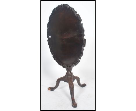 A 19th century Georgian mahogany pie crust edge tilt top tripod wine table. Raised on splayed legs with hoof feet supporting 