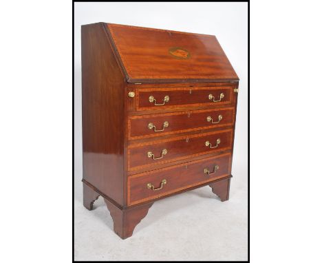 An Edwardian mahogany inlaid bureau desk being raised on bracket feet with a chest of drawers under fall front bureau having 