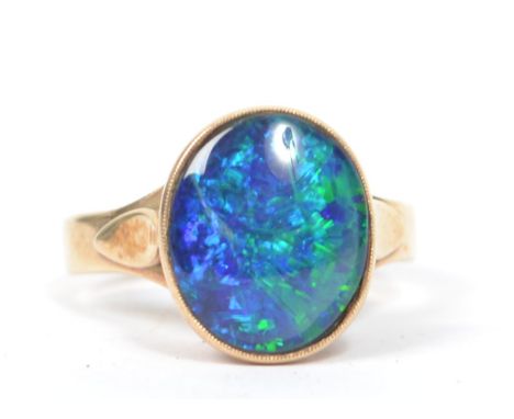 A 9ct gold vintage opal - doublet ring having a large central opal mounted in a pierced and sloped mount, weighs 4.3 grams me