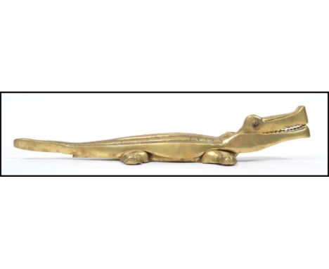 An early 20th century large novelty cast brass nut cracker in the form of a crocodile with opening jaw and detailed features.