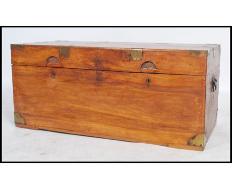 A 19th century Anglo-Indian camphor wood blanket box chest coffer of rectangular form with brass bracket work and carved half