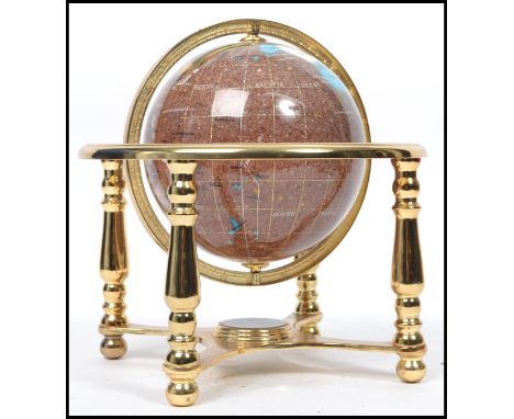 A small desk top 20th century spherical globe having semi precious stone inlay. The globe on pivots to a gilt metal turned ba