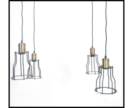 A group of four vintage industrial style pedant ceiling cage lights, black wire work cages with attached ceiling rose.