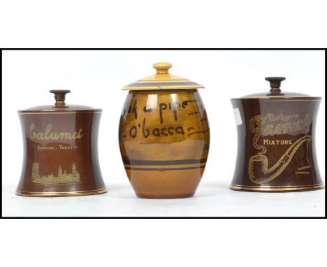 A group of three early 20th century pipe tobacco advertising point of sale ceramic storage jars, one motto ware example with 