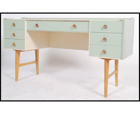 A vintage 20th century up cycled two tone painted twin pedestal knee-hole desk having an arrangement of drawers raised on tap