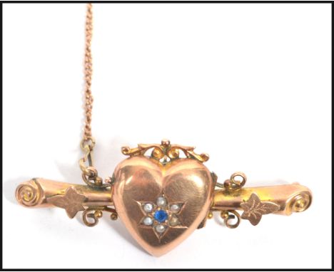 A hallmarked 9ct gold bar brooch having a heart locket with seed pearls and sapphire set to a star setting with scrolled ends