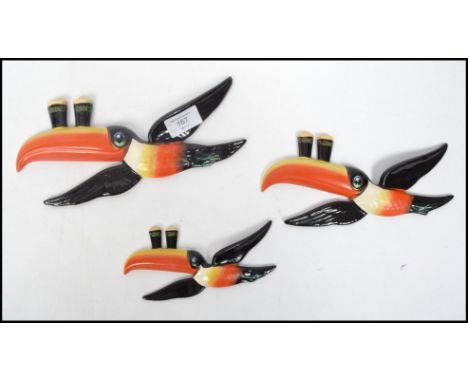 A set of three vintage 20th century Carlton Ware ceramic Guinness advertising graduating toucan wall plaques with painted and