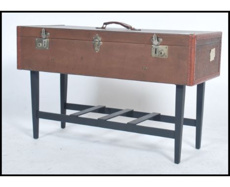 A vintage retro 20th century up-cycled coffee table constructed from a leather suitcase with locks to front raised on ebonise