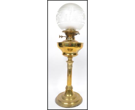 An early 20th century brass and frosted glass oil lamp in the neo classical style. The brass reservoir with twin handles,flue