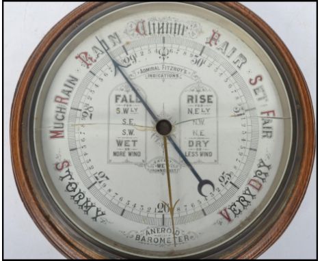An early 20th century Admiral Fitzroy's wheel barometer having white glass indicating dial set within an oak case.&nbsp;Measu