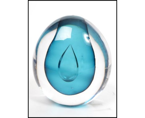 A vintage 20th century studio art glass paperweight of spherical form having a central clear raindrop. Measures 15 cm high an