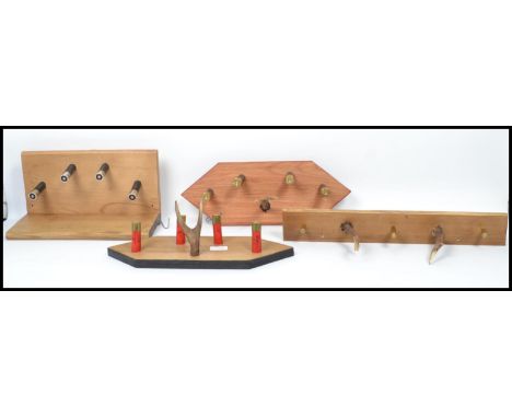 An unusual group of vintage taxidermy hunting interest antler and shot gun shell coat racks mounted on wooden backs. Highest 