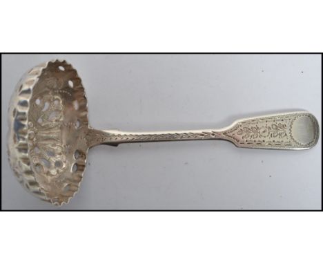 A silver hallmarked tea caddy strainer spoon having a pierced bowl and decorative handles. Birmingham hallmarks for HIlliard 
