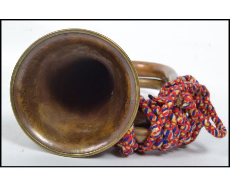 A vintage 20th century military brass copper and white metal bugle complete with mouthpiece and rope. Measures 16 cm high and