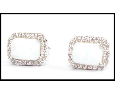 A pair of ladies silver and opal earrings. The opals on prong settings complete with post backs in the presentation case. Wei