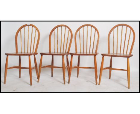 A set of four Ercol hoop back dining chairs in beech and elm having the blonde finish. measures 88 x 40 x 44