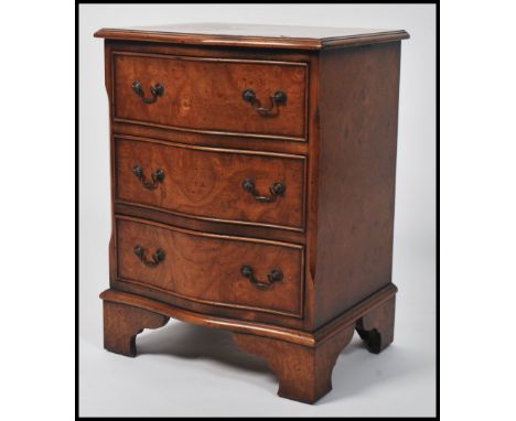 A vintage 20th century 1930s Burr Walnut serpentine bedside chest of three drawers. Raised on bracket feet, drop swag handles