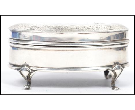 An early 20th century Edwardian silver hallmarked lidded pot raised on four legs with chased decorated lid opening to reveal 
