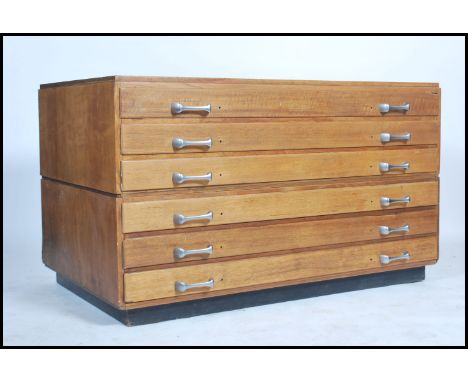 A vintage mid century oak twin section Industrial architects plan chest of drawers. Raised on an inset plinth base with reces