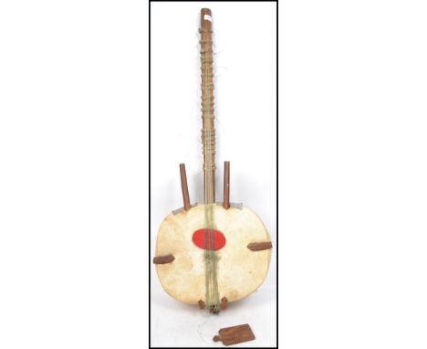 A vintage 20th century unusual large mandolin musical instrument having a wooden body with animal hide stretched over. Measur