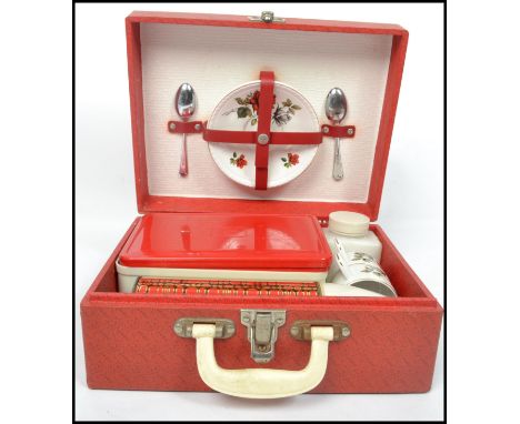 A vintage retro 20th century Brexton portable picnic hamper set in a red vinyl case with fitted interior with flasks, cutlery