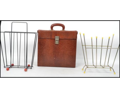 Two vintage 20th century retro sputnik atomic style magazine racks one having an ebonised finish with red all finials and the