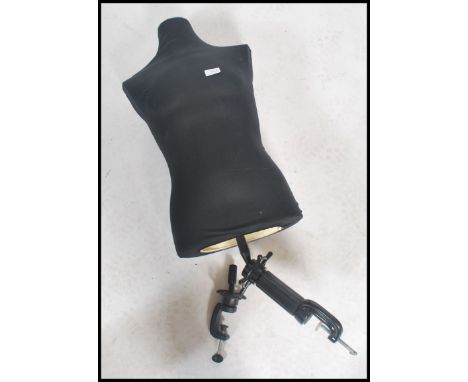 A vintage retro 20th century dress makers mannequin - shop tailors dummy raised on an adjustable clamp stand.