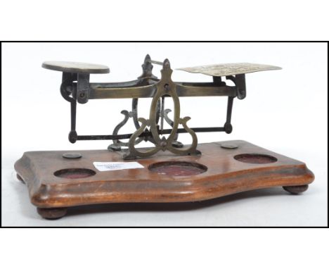 A set of vintage 20th century post office scales raised on a wooden base with bun feet having a pierced metal mount. Measures