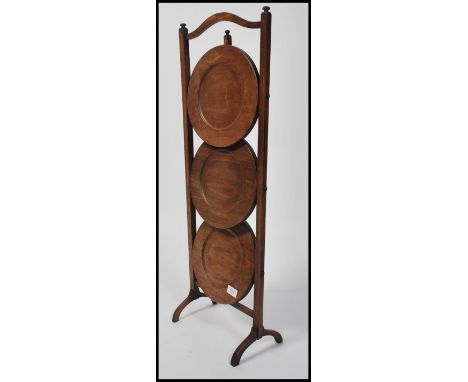 A vintage 1930's metamorphic oak cake stand, with folding trays to centre and carry handle to top