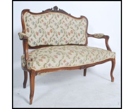 A good French early 20th century canape two seat sofa in mahogany having reeded, carved legs and shaped apron with carved elb