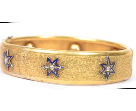 A 19th century 15ct gold and diamond chatelaine bangle bracelet decorated with a etched swirls with stud and enamel stars.&nb