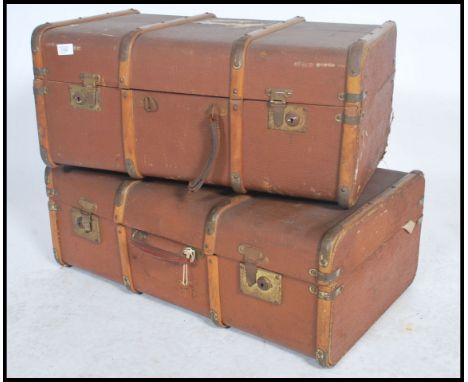 A pair of vintage 20th century canvas and wooden bound steamer trunks with locks and claps to front with hinged lids opening 