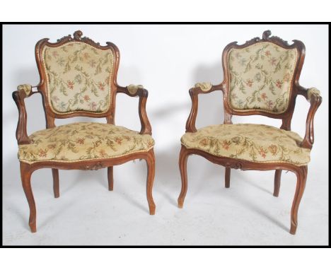 A good pair of French fauteil's / armchairs in mahogany having reeded, carved legs and shaped apron with carved elbow rests a