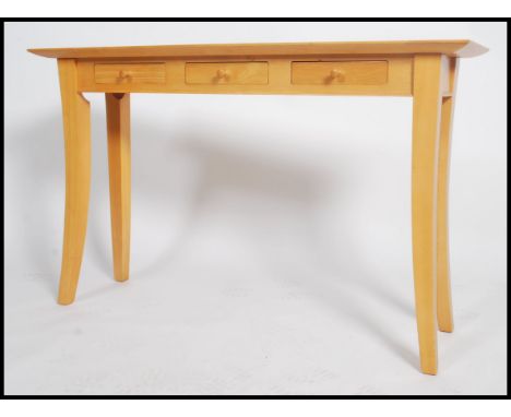 A 20th century Marks and Spencer's beech console table, raised on sabre legs, three drawers under flared&nbsp; edge table top