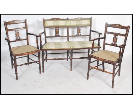 A pair of Edwardian marquetry inlaid salon armchairs together with a matching two seat salon sofa settee having pierced backs