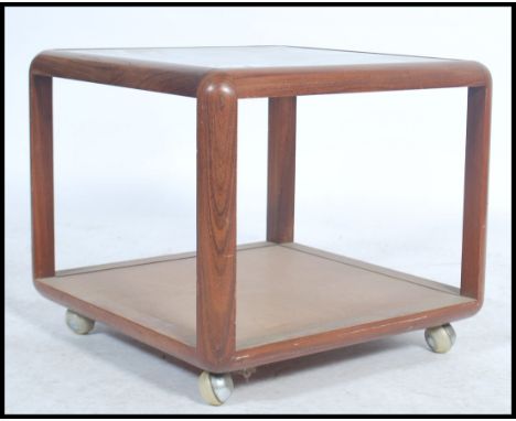 A vintage retro 20th century teak wood G-Plan square coffee table having a glass insert raised on castors.