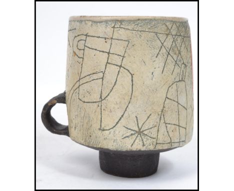 John Maltby (b.1936) A rare and unusual mid 20th century studio pottery cup having a small handle raised on a small circular 