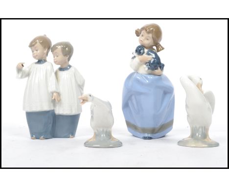 A pair of vintage 20th century Lladro ceramic geese along with a Nao figurine group of choir boys and a Nao girl with dog. Hi