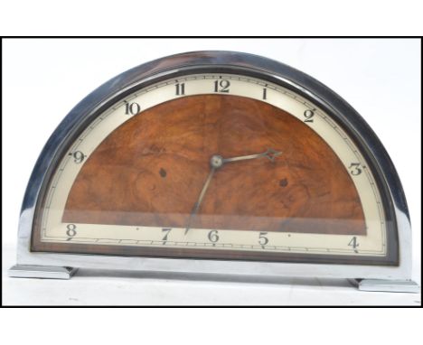 A vintage 20th century Art Deco chrome and walnut mantel clock of half moon form with silvered dial and faceted hand stamped 