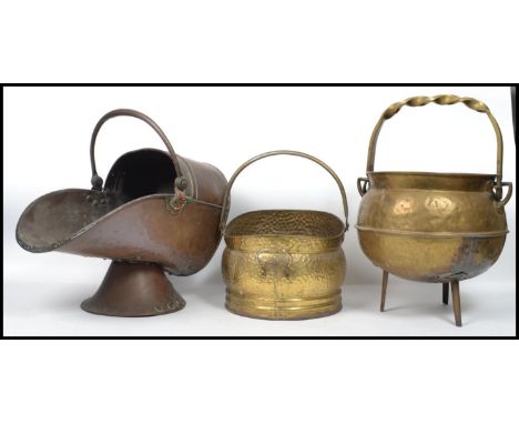 A group of copper and brass coal scuttles dating from the 19th century to include an example with a twist handle raised on tr