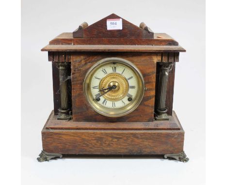 A late Victorian oak cased mantel clock, of architectural form, having enamelled chapter ring with Roman numerals and eight d