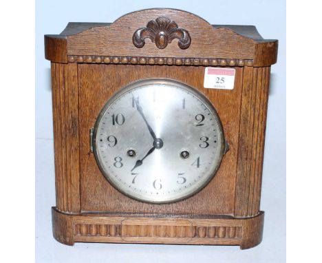 A 1930s oak cased mantel clock having a silvered dial with Arabic numerals and eight day movement, height 26cm