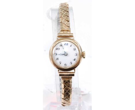 A lady's 9ct gold manual wind wristwatch, having an unsigned white enamel dial, case dia.21mm, on replacement expanding link 