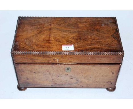 A late Regency rosewood tea caddy having moulded edges on bun feet, the interior with twin compartments and central mixing bo