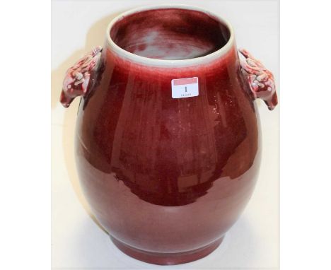 A large Chinese red flambe glazed stoneware vase, of pear shape having twin antelope handles with incised six character mark 